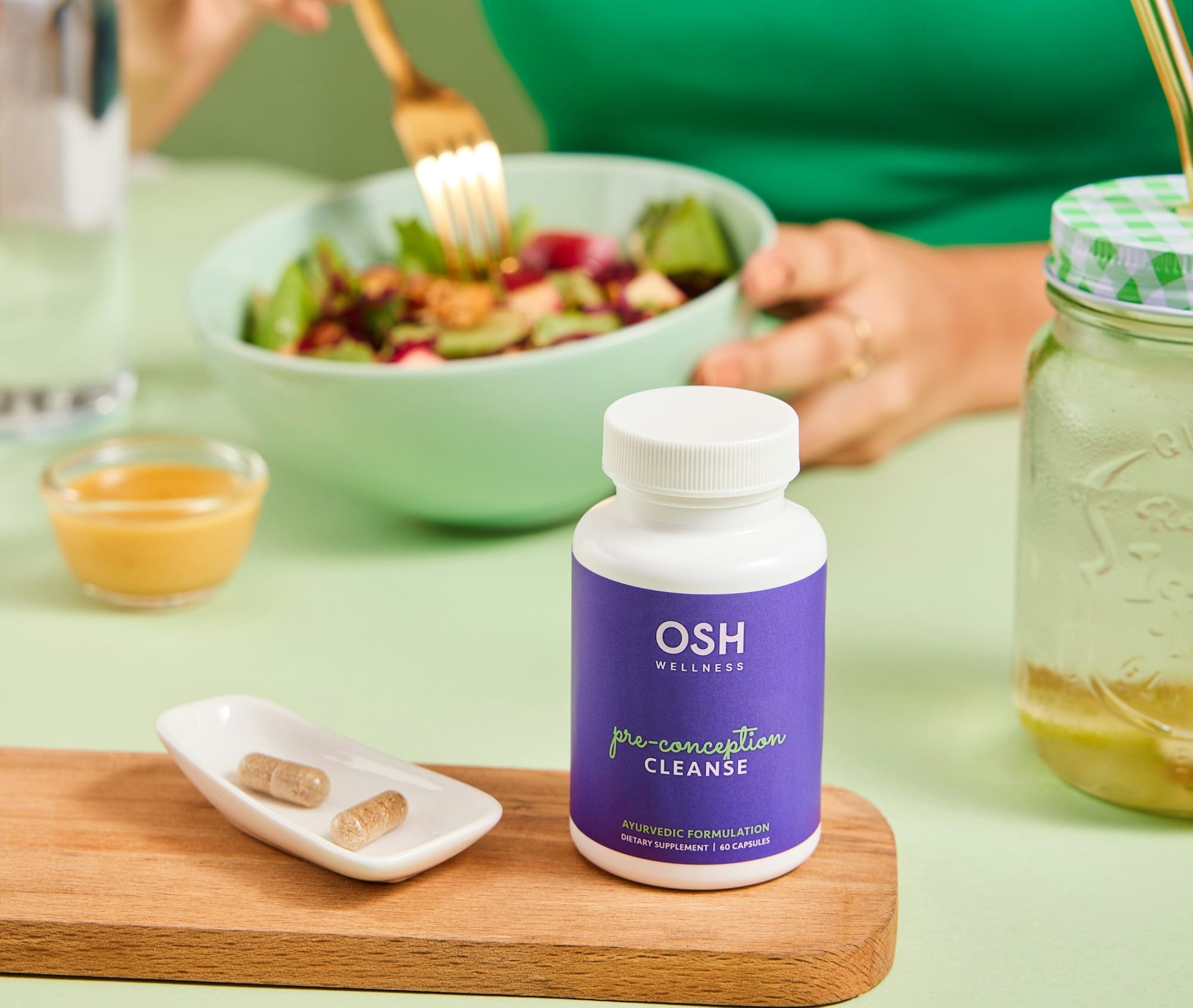 A woman sitting at a table with a bowl of salad