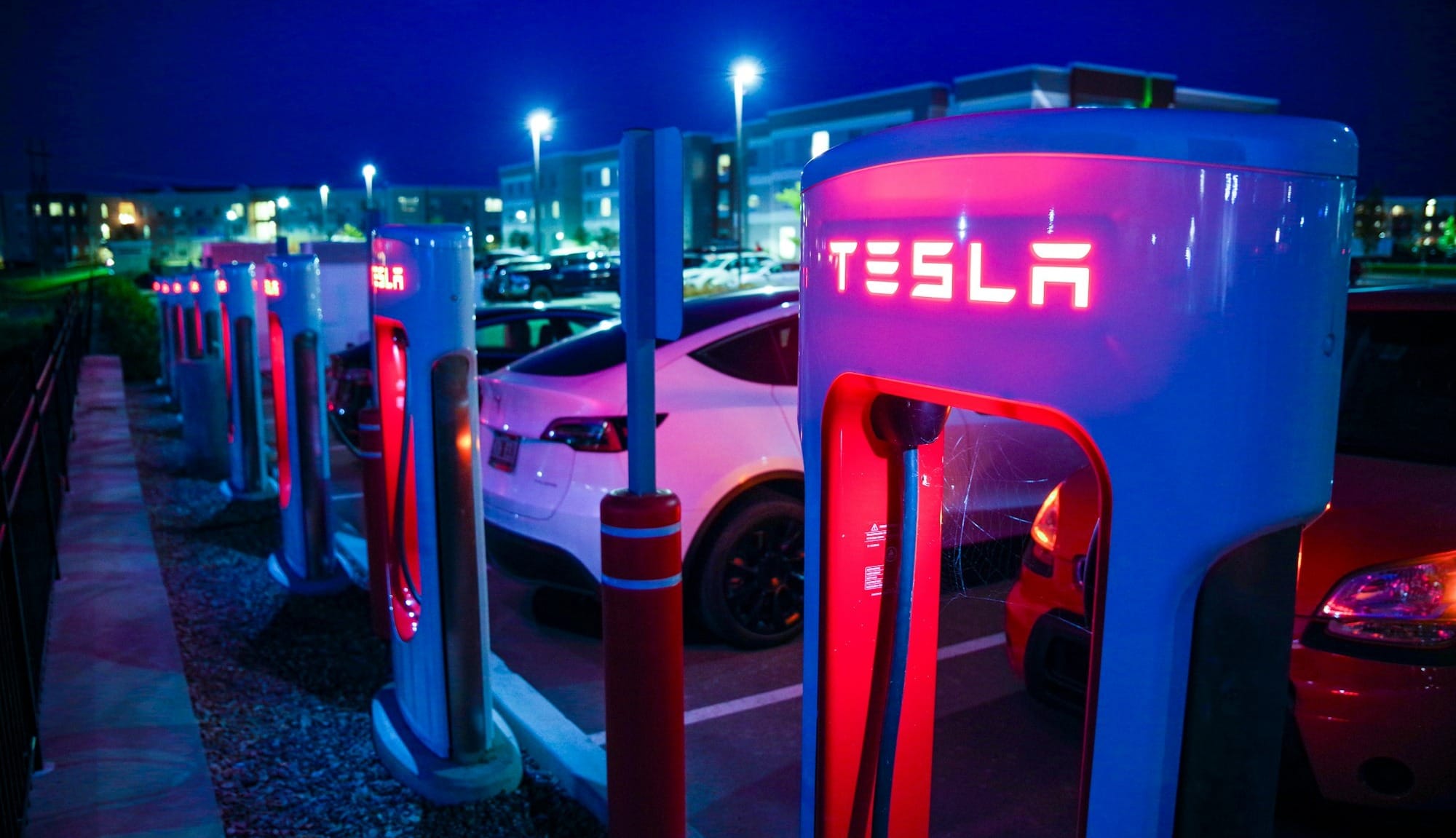a row of tesla charging stations at night
